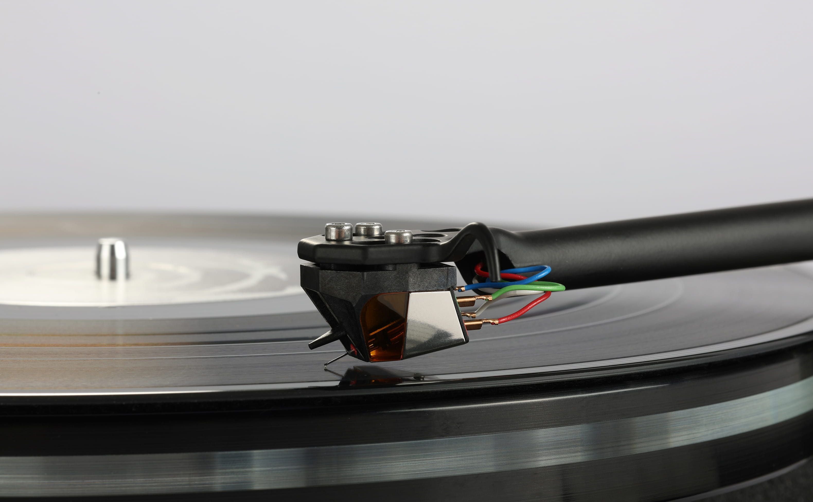 Rega ND9 Moving Magnet Phono Cartridge on a turntable playing a vinyl record.
