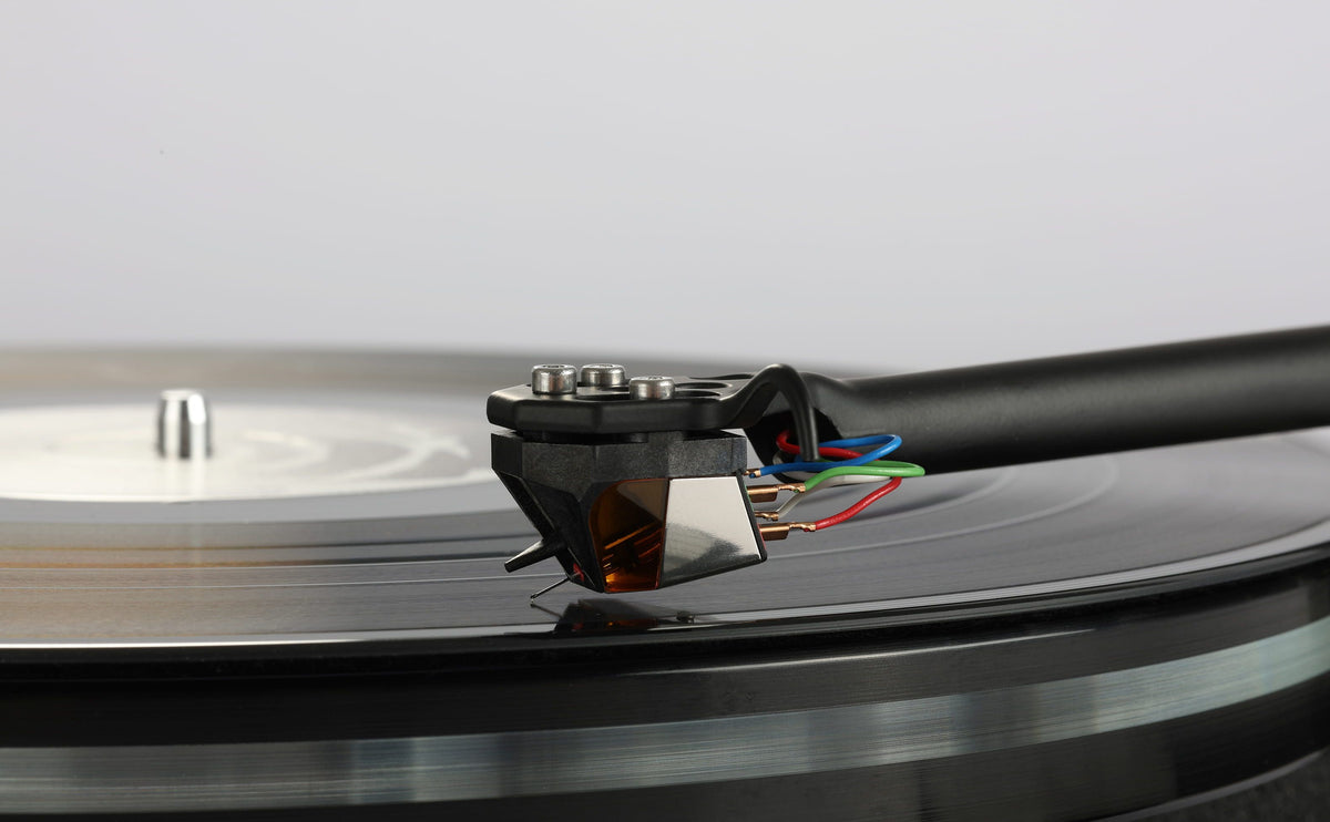 Rega ND9 Moving Magnet Phono Cartridge on a turntable playing a vinyl record.