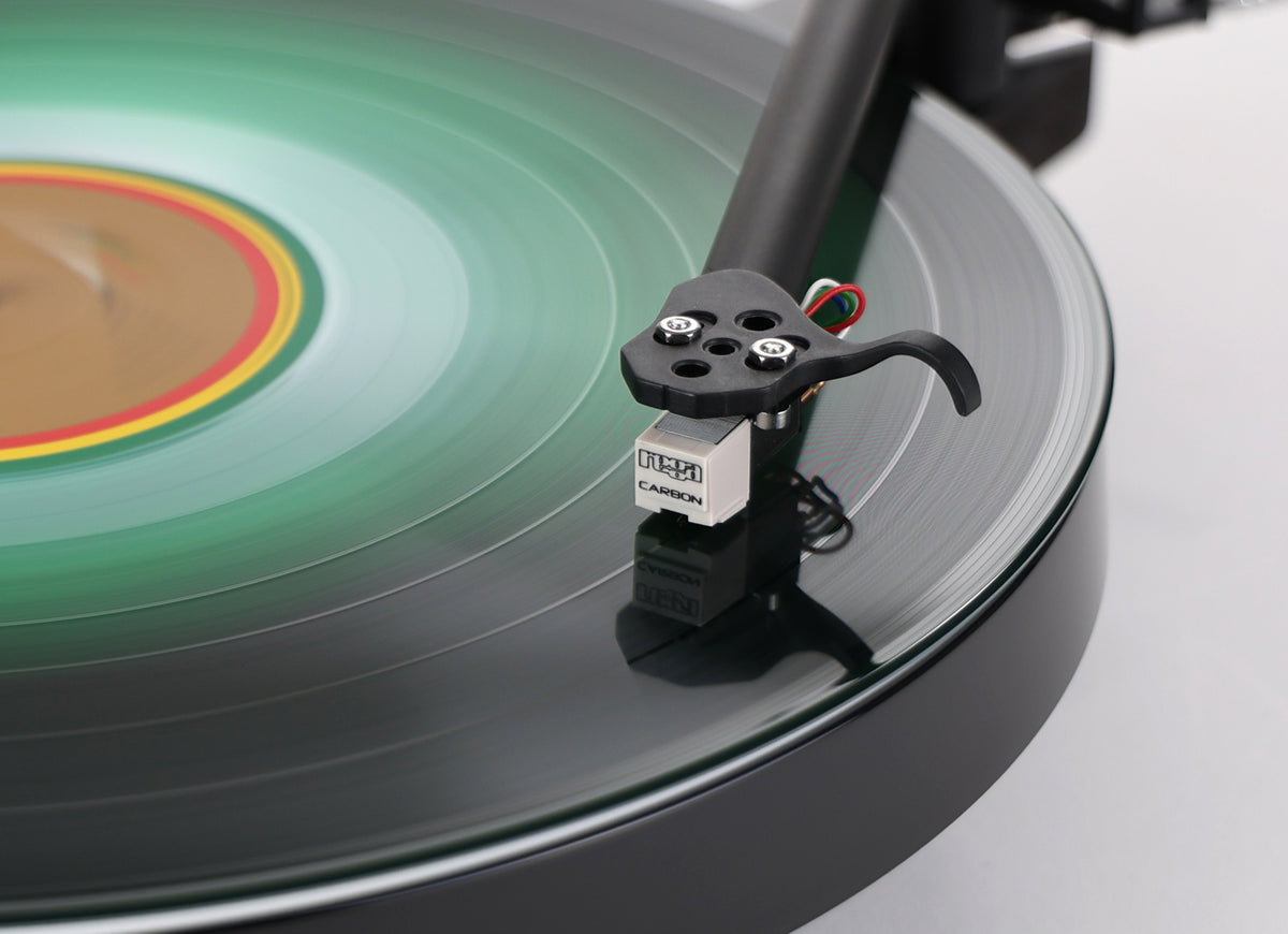 Rega Replay Plug and Play Turntable with Rega Carbon Cartridge close-up of the tonearm and cartridge on vinyl record.