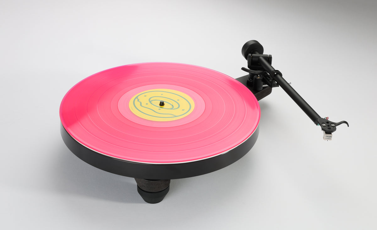 Rega Replay Plug and Play Turntable with Rega Carbon Cartridge featuring a vibrant pink vinyl record.