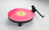 Rega Replay Plug and Play Turntable with Rega Carbon Cartridge featuring a vibrant pink vinyl record.