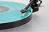 Rega Replay Plug and Play Turntable with Rega Carbon Cartridge playing a turquoise vinyl record.